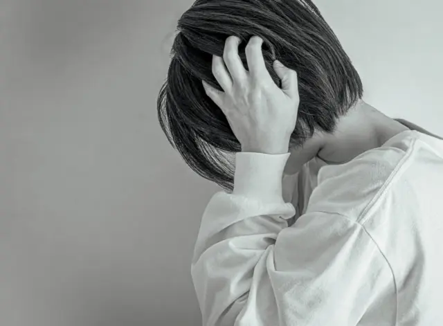 耳をふさぐ女性