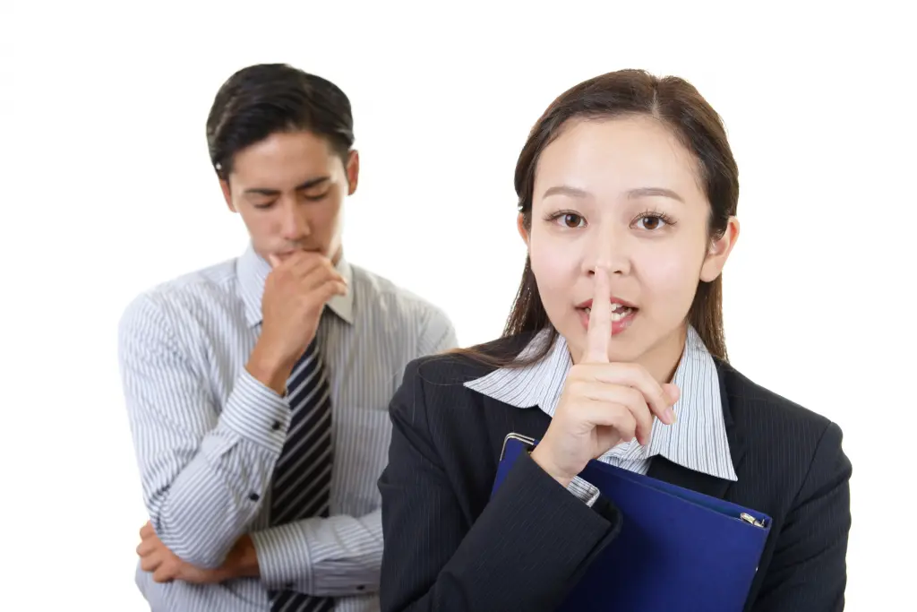 口元に指を当てて内緒のポーズをする人