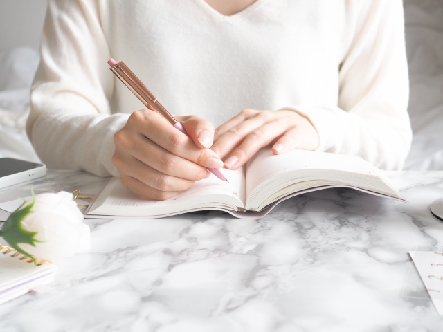 ノートにまとめる女性