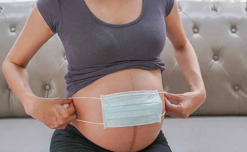 妊娠中のインフルエンザワクチンはいつから？　妊婦　お腹　マスク　写真