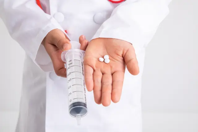 白衣を着た子どもの手元