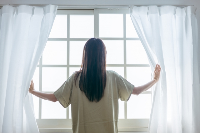 窓を開ける女性