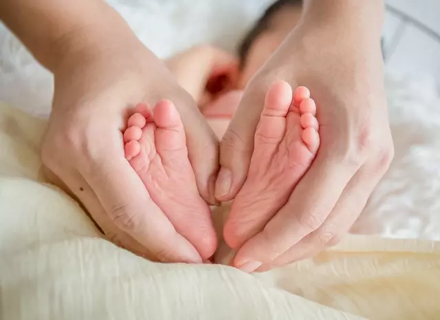 大人の手で赤ちゃんの足を包む