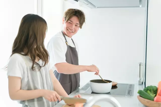 家のキッチンで一緒に料理を作る若い夫婦